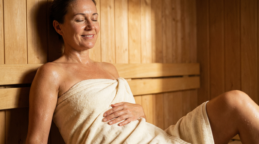 Entspannte Frau in der Sauna lindert Regelschmerzen durch Wärme.