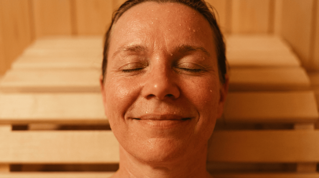 Der Saunaaufguss als achtsamer Anker-Moment gegen Burnout und Stress. frau in der sauna lacht weil sie kurzzeitig alles vergessen kann.