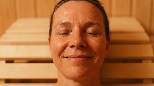Der Saunaaufguss als achtsamer Anker-Moment gegen Burnout und Stress. frau in der sauna lacht weil sie kurzzeitig alles vergessen kann.