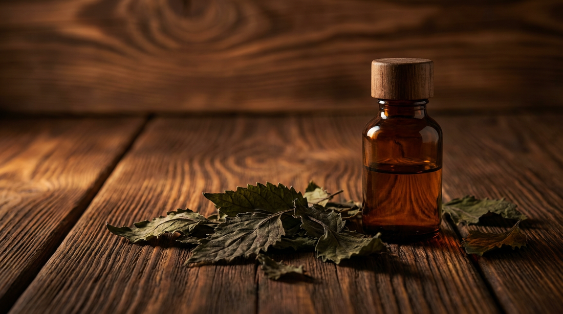 Patchouli ätherisches Öl in dunkler Glasflasche mit getrockneten Patchouliblättern auf rustikalem Saunaholz für entspannenden Saunaaufguss