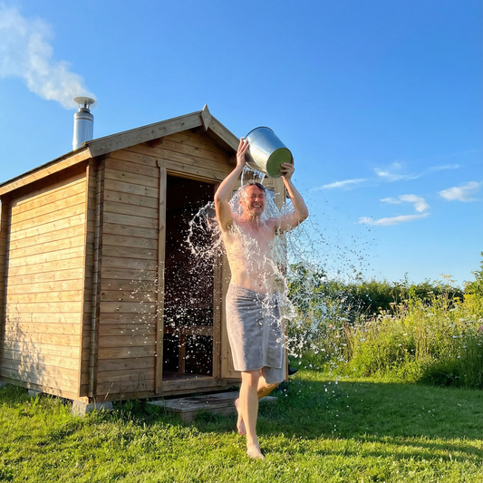 Abkühlung mit kaltem Wasser nach der Gartensauna im Sommer.