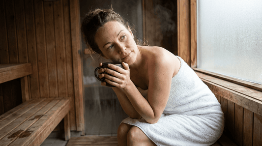 Frau entspannt im Saunabereich mit Teetasse - symbolisiert Erholung nach Blasenentzündung